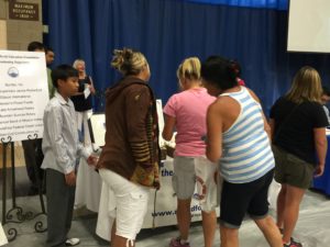 Teachers line up to purchase Nathan's art work at the 2016 Back to School Breakfast